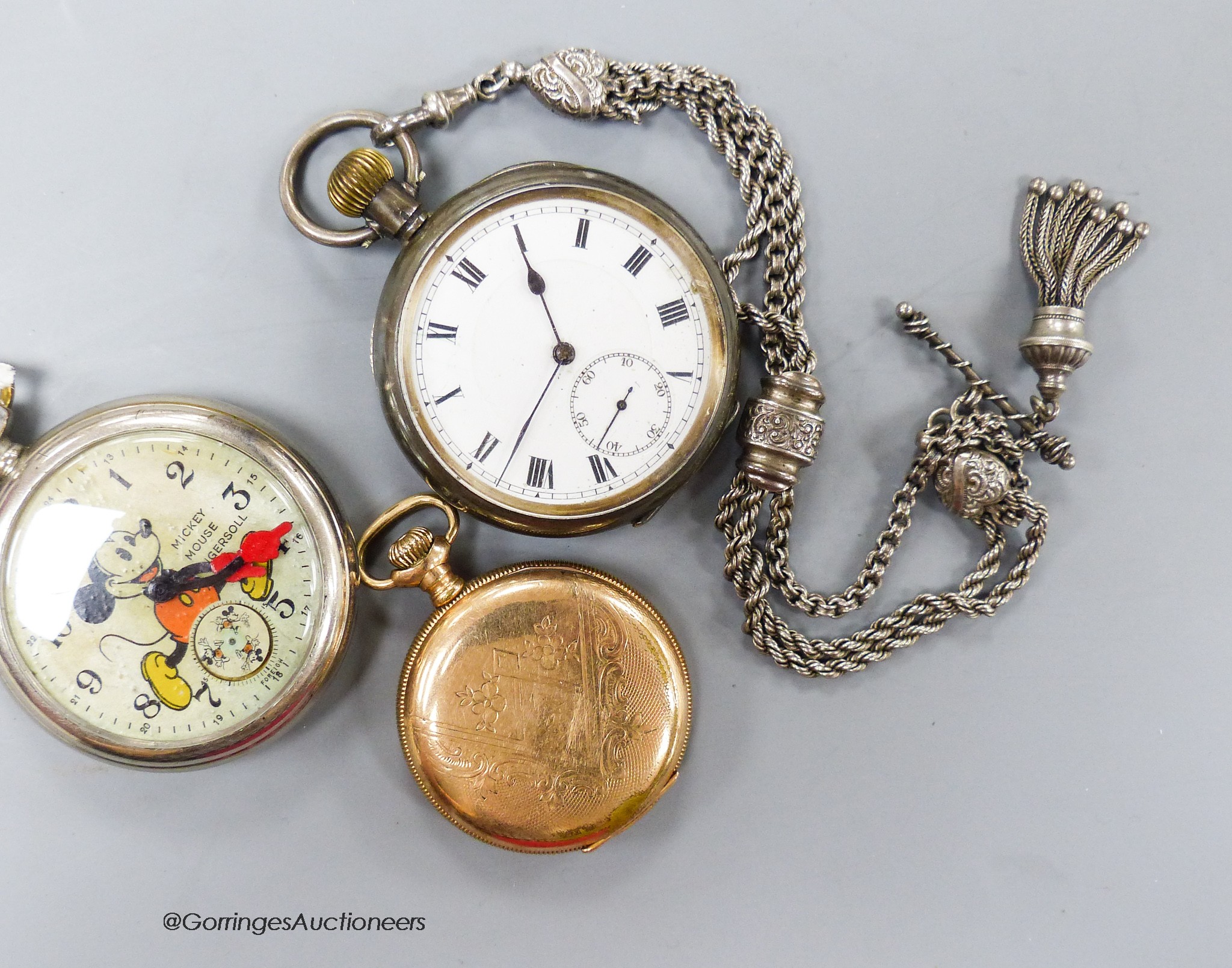 An Ingersoll Mickey Mouse pocket watch, a silver pocket watch on white metal albertina and a gold plated pocket watch.